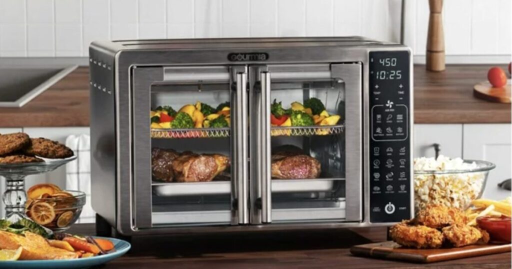 Gourmia Toaster Oven Air Fryer Combo Review – A sleek stainless steel Gourmia toaster oven air fryer combo with French doors, cooking steak, vegetables, and crispy fried food, displayed on a modern kitchen countertop. | best kitchen reviews