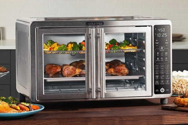 A modern stainless steel Gourmia Digital Air Fryer Oven with French doors, featuring a digital control panel, cooking crispy chicken and vegetables on multiple racks in a stylish kitchen setting. This image represents How to Use Gourmia Digital Air Fryer Oven for preparing delicious and healthy meals.